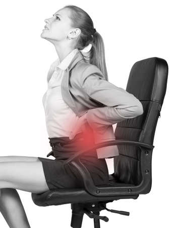Businesswoman with lower back pain, sitting on office chair. Isolated over white の写真素材