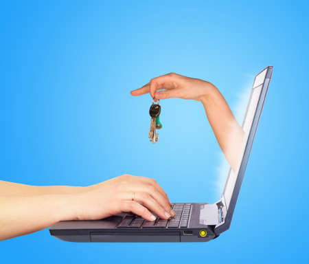 Key holding in hand from monitor screen. Hands typing on keyboard. Blue backgroundの写真素材