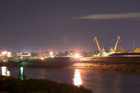 Industrial area with river port. Behind the houses, in front of river. Night viewの写真素材
