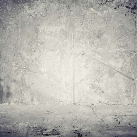 Old gray cement wall with cracks and dirtの写真素材
