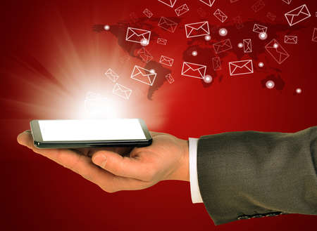 Business man holding mobile phone within left hand. Sending and getting emails. Abstract world on...