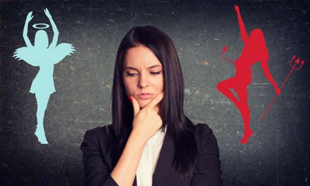 Businesswoman with thoughtful face on grey wall backgroundの写真素材