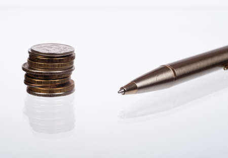 Pen with coins on isolated white background, side viewの写真素材