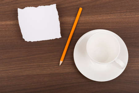 Blank piece of paper with pencil and tea cup on brown wood tableの写真素材