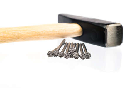 Hammer with red handle and scattering nails on isolated white background, close-up viewの写真素材
