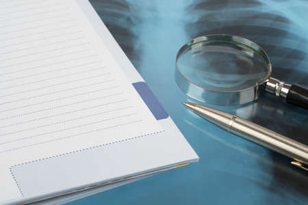 X-ray examination and pen with notebook, close-up view