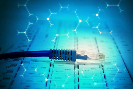 Computer cable on keyboard in abstract blue background with signsの写真素材