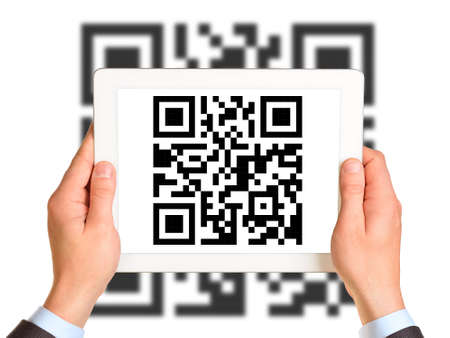 Businessmans hands holding picture with QR-code on isolated white background with codeの写真素材