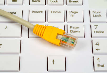 Yellow cable on white keyboard with buttonsの写真素材