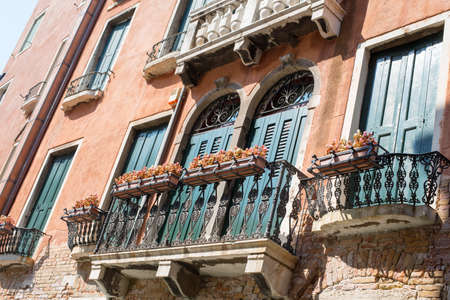 Building with balconies and flowers on blue skyの写真素材