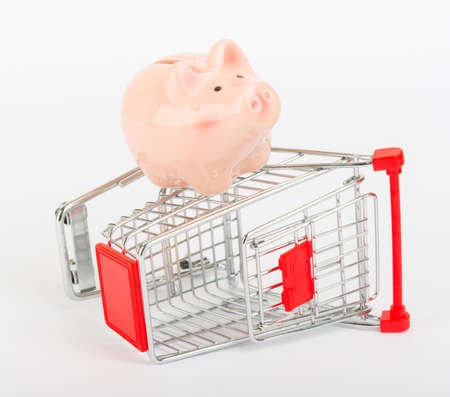 Piggy bank on shopping cart on isolated white background, side viewの写真素材