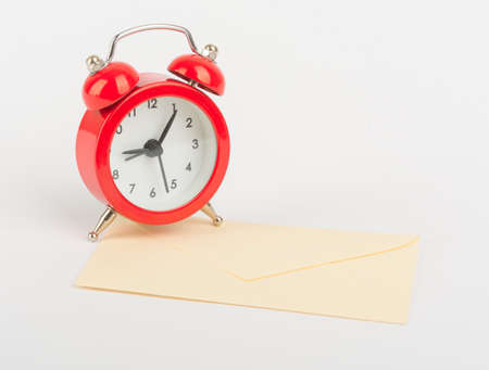 Red alarm clock on envelope on isolated white backgroundの写真素材