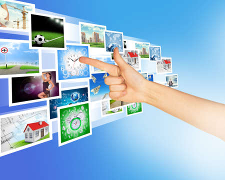 Arm pointing at holographic pictures on abstract backgroundの写真素材