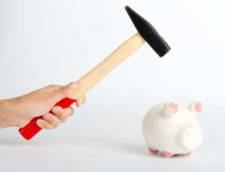 Humans hand with hammer and piggy bank on isolated white background, close up viewの写真素材
