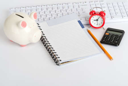 Drafts and exercise book with calculator and piggy bankの写真素材