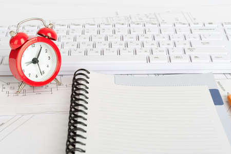Drafts and exercise book with keyboard and alarm clockの写真素材