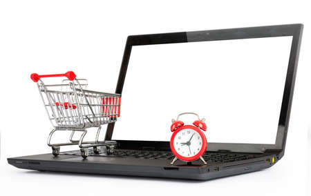 Shopping cart and alarm clock on laptop on isolated white background, close up viewの写真素材