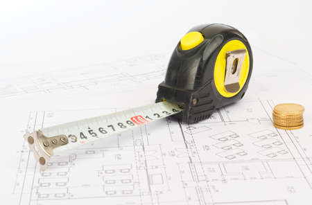 Tape measure with coins on draft background