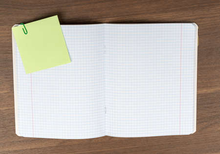 Open copybook with sticker on wooden table