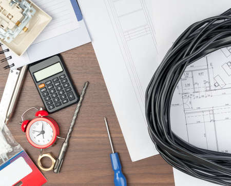 Drafts with alarm clock and screwdriver and cable on tableの写真素材