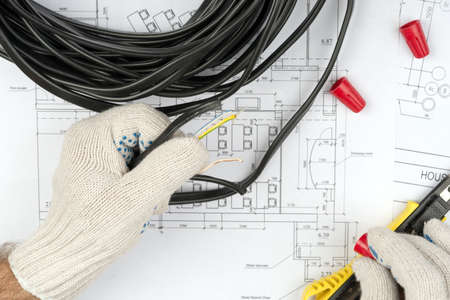 Mans hands holding cable on draft background