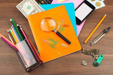 Colorful notebooks with office suppleis on wooden tableの写真素材