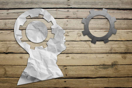 Paper humans head with wheel symbol on wood deck backgroundの写真素材