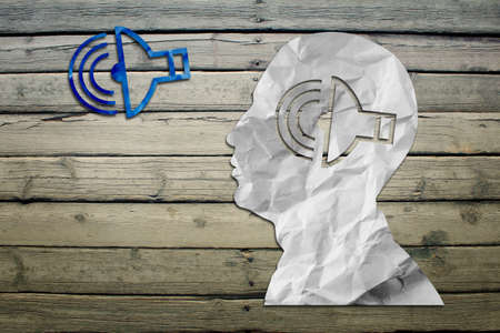 Paper humans head with sound symbol on wood deck backgroundの写真素材