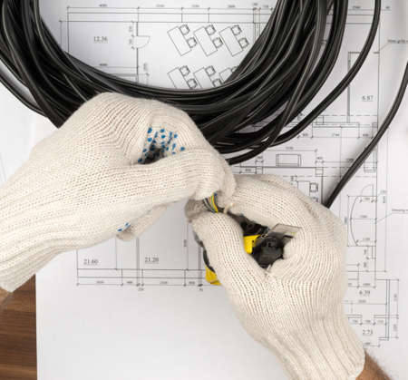 Mans hands holding cable on draft backgroundの写真素材