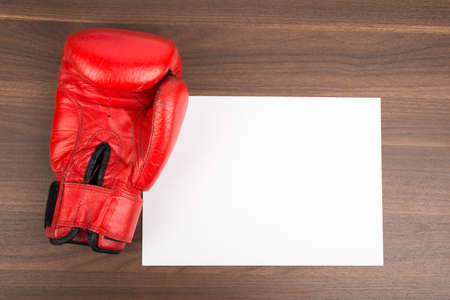 Blank card with boxing glove on wooden tableの写真素材