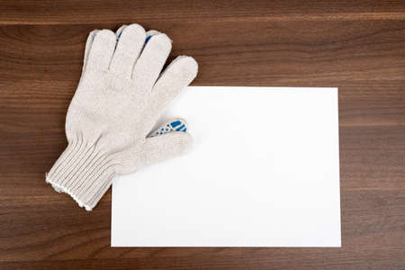Blank card with gloves on wooden table