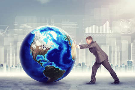 Businessman pushing Earth on abstract background. Elements of this image furnished by NASAの写真素材