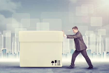 Businessman pushing big white box on abstract backgroundの写真素材