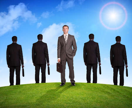 Set of businessmen on nature background with green grass and blue skyの写真素材