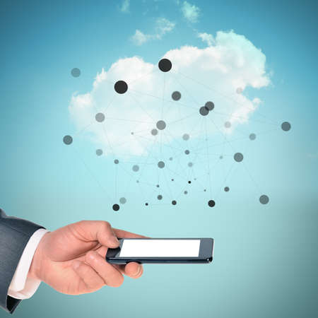Businessman arm holding smartphone on blue sky background