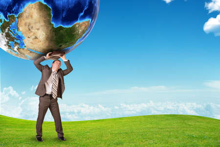 Businessman standing on ground with suitcase and earthの写真素材