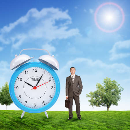 Businessman with suitcase and big alarm clock