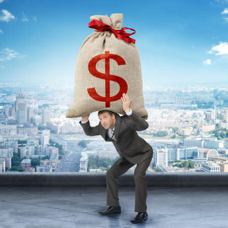 Businessman holding big moneybag with dollar signの写真素材