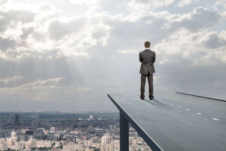 Businessman standing on road in sky, rear view. Business concept