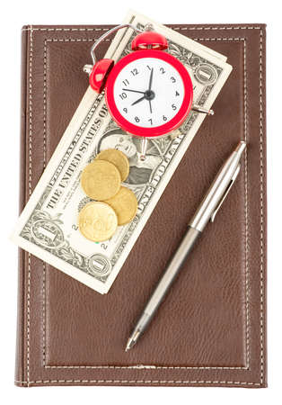 Leather daily planner with pen and cash and alarm clock on isolated white backgroundの写真素材