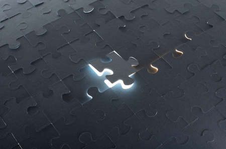 Grey puzzle background with flying piece, close up viewの写真素材
