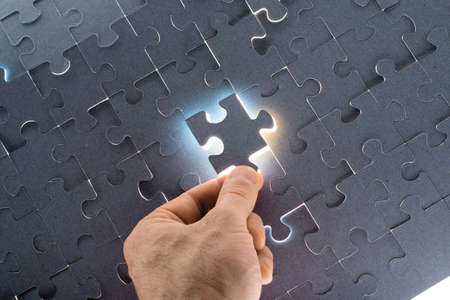 Man putting puzzle piece, close up viewの写真素材