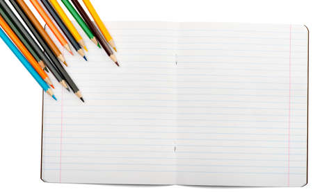 Open notebook with crayons on isolated white background, closeup