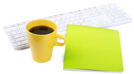 Keyboard with cup of coffee and notebook on isolated white background, closeupの写真素材
