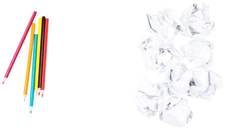 Blank piece of paper with crayons and crumpled paper balls on isolated white backgroundの写真素材