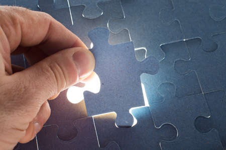 Man putting puzzle piece, close up viewの写真素材