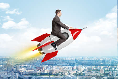 Businessman flying on drawn rocket above cityscape