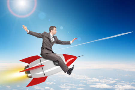 Businessman flying on drawn rocket above cloudscapeの写真素材