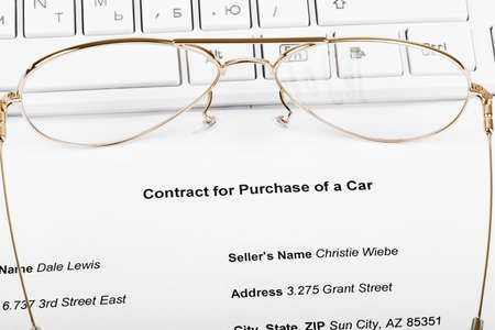 Keyboard with eyeglasses and document of purchase of car