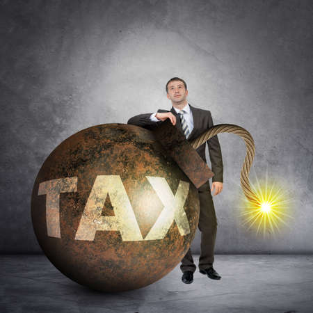 Businessman with big tax bomb with lighting wickの写真素材